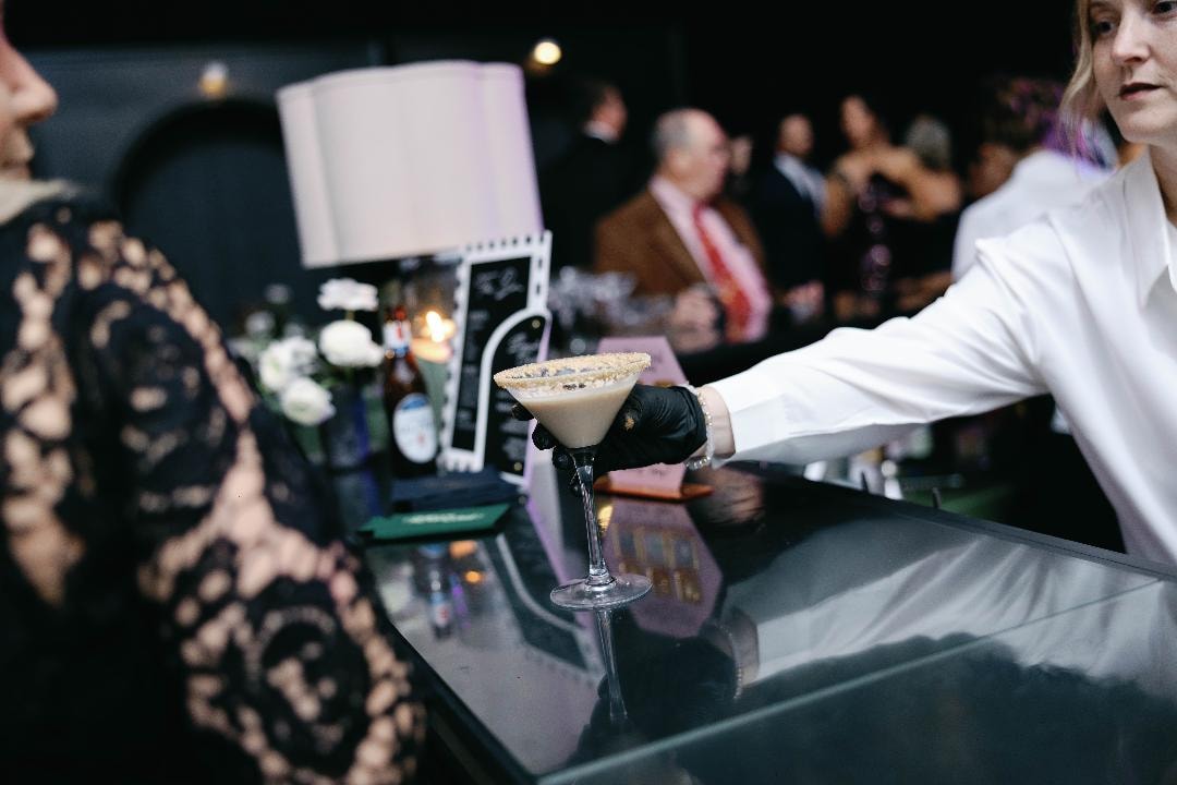 Bartender serving a signature cocktail at a wedding